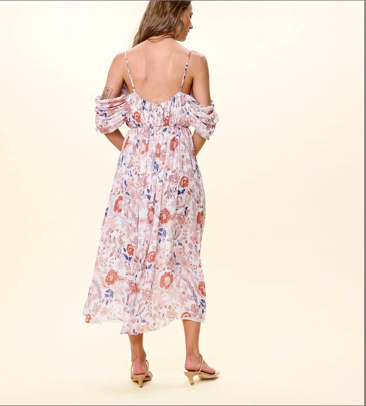 Woman wearing a floral dress with a plain background