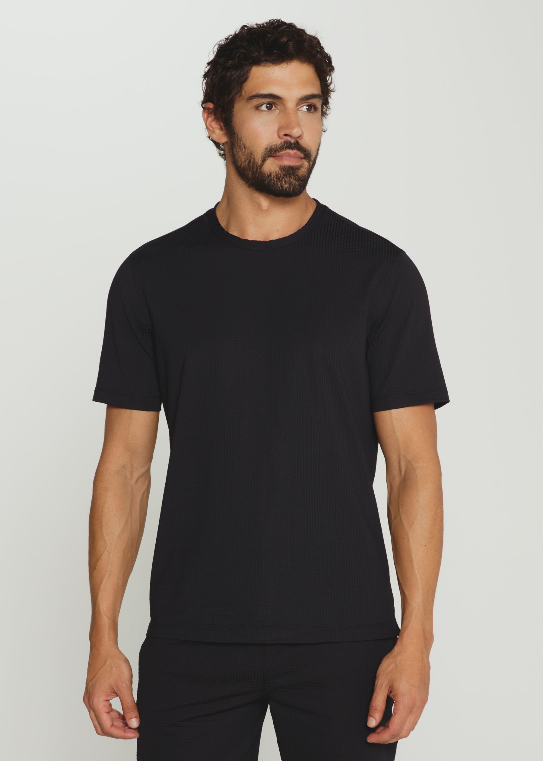 Man wearing a black t-shirt against a plain background