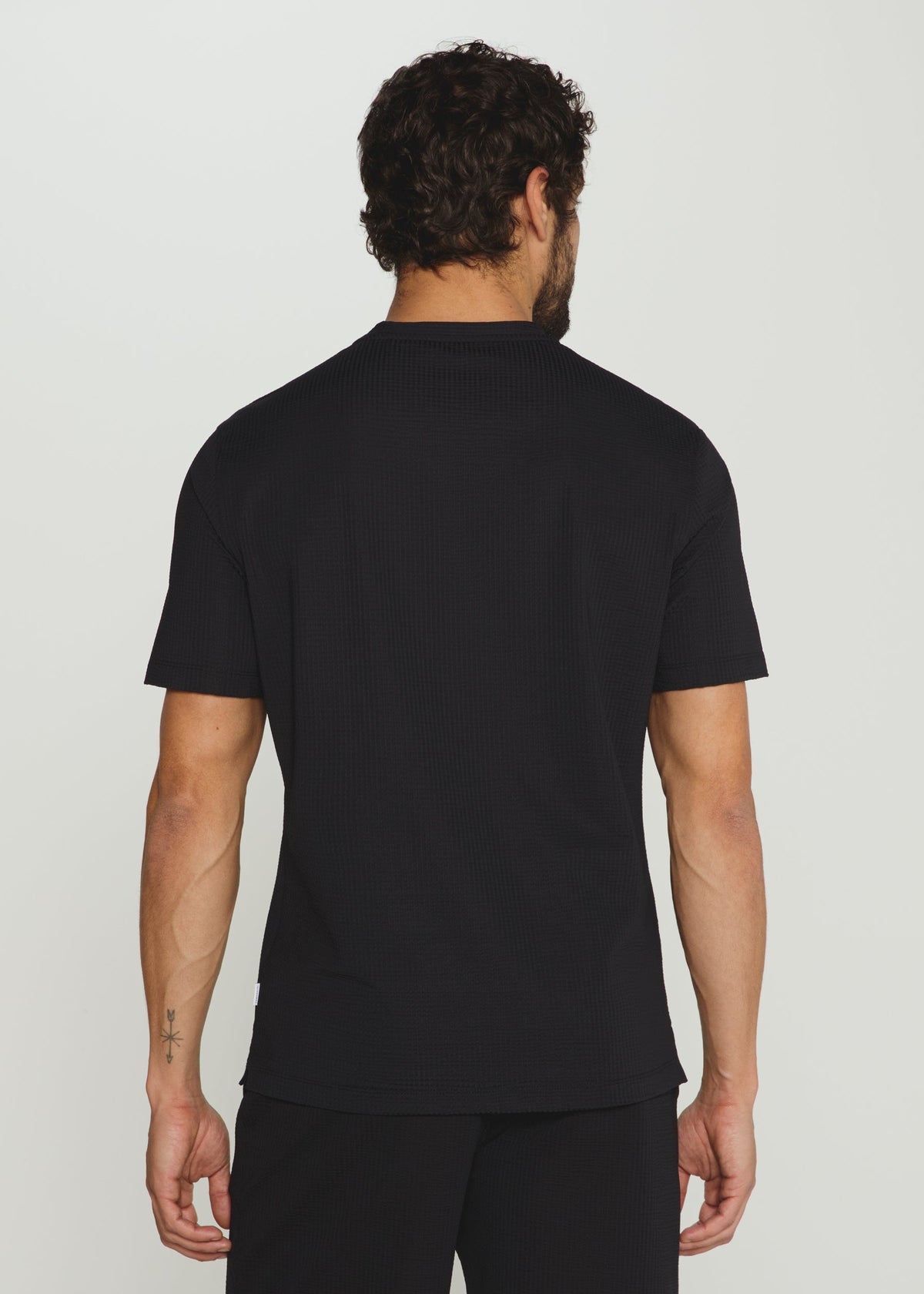 Man wearing a black t-shirt against a plain background