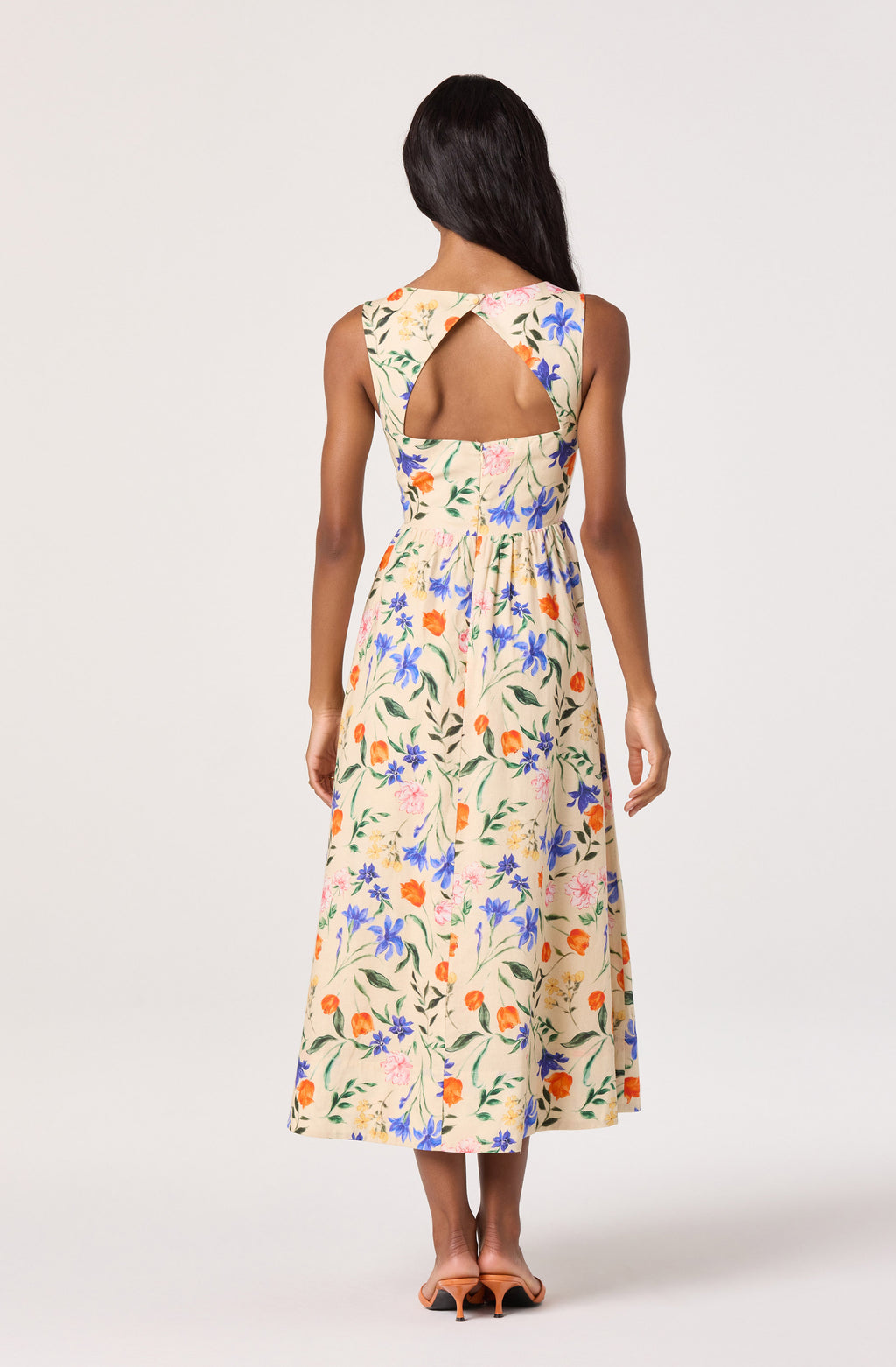 Woman wearing a floral dress with a cutout back on a white background