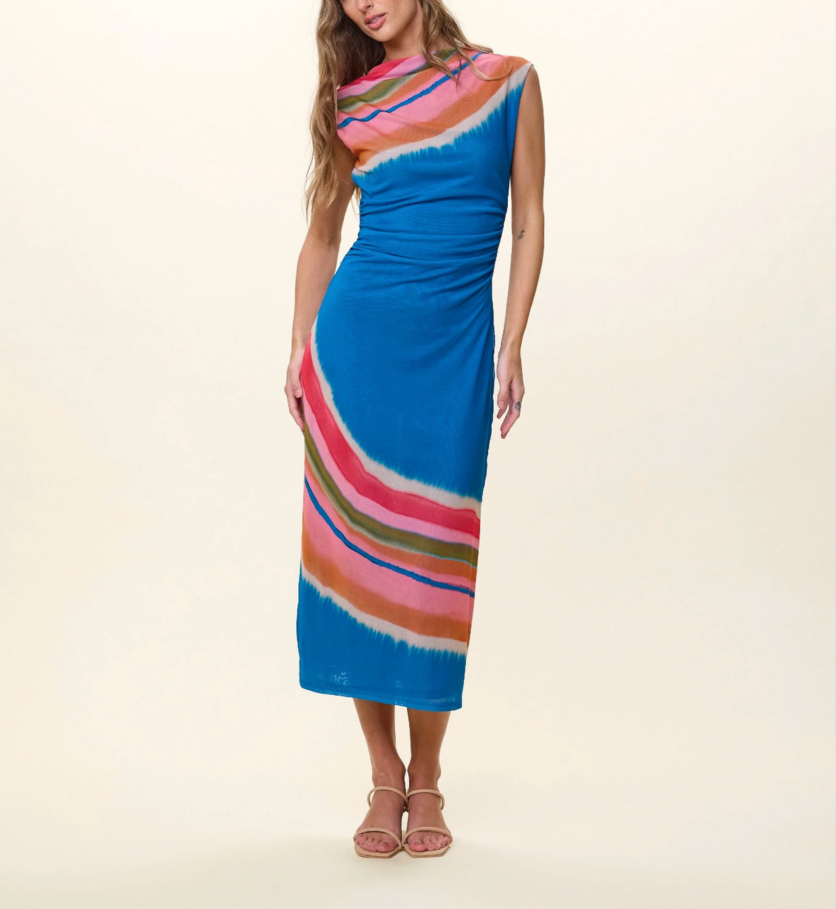Woman wearing a colorful dress with a blue base on a beige background