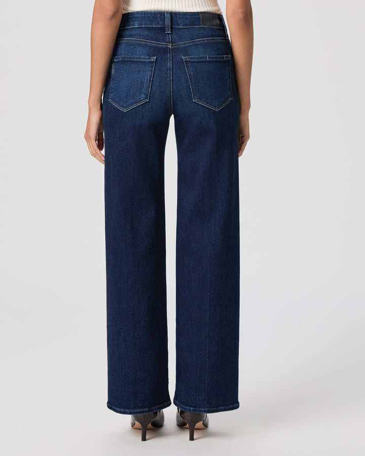 Person wearing dark blue jeans on a white background