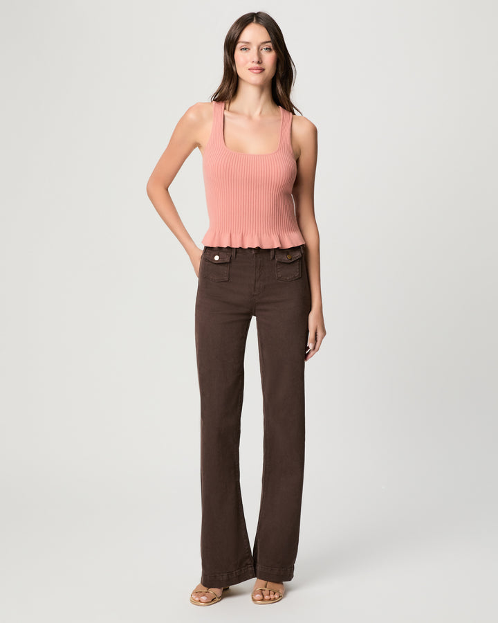 Woman wearing a pink top and brown pants on a white background