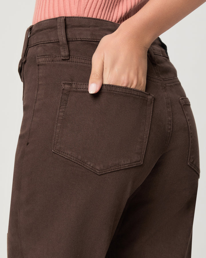 Brown pants with a pocket, worn by a person, on a plain background